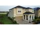 Two-story home featuring a brick paved driveway and a tan exterior at 1544 Nassau Point Trl, Kissimmee, FL 34747