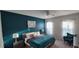 Cozy bedroom featuring a teal accent wall, ceiling fan, and carpet at 1544 Nassau Point Trl, Kissimmee, FL 34747