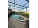 Screened in pool and hot tub with brick pavers and lawn outside the screen at 1544 Nassau Point Trl, Kissimmee, FL 34747