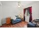 Comfortable bedroom featuring wood floors, window with blinds, and blue sofa for relaxation or use as an office at 189 Lakeside Cir, Sanford, FL 32773