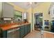 Efficient kitchen with stainless steel appliances, warm wood countertops, and a view into the adjacent dining area at 189 Lakeside Cir, Sanford, FL 32773