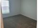 The carpeted bedroom offers a view through a bright window for a peaceful retreat at 2002 Punch Bowl Ave, Davenport, FL 33837