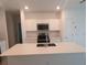 Modern kitchen featuring stainless steel appliances, a central island with sink, and white cabinets at 2002 Punch Bowl Ave, Davenport, FL 33837