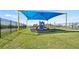 Community playground area with blue slide under a shade structure, surrounded by green grass at 2227 Chris Dr, Winter Haven, FL 33884