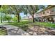 Serene backyard of lakeside property featuring lush greenery, a sidewalk, and views of neighboring homes at 2343 Caravelle Cir, Kissimmee, FL 34746