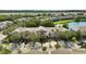 Exterior view of pink townhomes with mature landscaping and sidewalks in a lush community near a lake at 2343 Caravelle Cir, Kissimmee, FL 34746