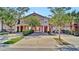 Charming townhome featuring a well-maintained lawn and colorful exterior with mature landscaping at 2343 Caravelle Cir, Kissimmee, FL 34746