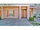 Attractive townhouse featuring brick paved driveway, tidy landscaping, and an ADT security system at 2343 Caravelle Cir, Kissimmee, FL 34746