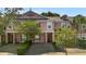Inviting townhouse showcasing a vibrant exterior, mature landscaping, and paver driveway at 2343 Caravelle Cir, Kissimmee, FL 34746