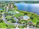 Aerial view showcasing community amenities including a pool, tennis courts, and playground, all near a lake at 2359 Baronsmede Ct, Winter Garden, FL 34787