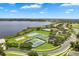 Aerial view of community amenities, including tennis courts, a pool, and waterfront homes on a scenic lake at 2359 Baronsmede Ct, Winter Garden, FL 34787