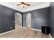 Open living room with wood-style flooring, dark paint, arched doorways, and ceiling fan at 2359 Baronsmede Ct, Winter Garden, FL 34787