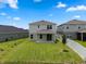 The house shows a spacious backyard with green grass, a covered patio, and a white fence at 2372 Orchid Dr, Davenport, FL 33837