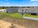 Aerial shot showcases backyard of two story home with verdant grass and a white fence at 2372 Orchid Dr, Davenport, FL 33837