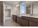 View of the bathroom with dual vanities, walk-in tiled shower, and neutral colored walls at 2372 Orchid Dr, Davenport, FL 33837