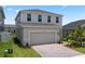 New home with a two car garage and a brick paver driveway surrounded by green grass and plants at 2372 Orchid Dr, Davenport, FL 33837