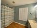 Well lit bathroom featuring a shower with patterned curtain, plantation shutters, and ample vanity storage at 2548 Galliano Cir, Winter Park, FL 32792