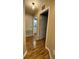 Hallway with hardwood floors leads to a powder room with white vanity and a white door at 2548 Galliano Cir, Winter Park, FL 32792