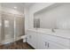 Modern bathroom with double sinks, granite countertops, white cabinetry, and a tiled shower at 3144 Suraj Cir, Tavares, FL 32778