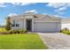 Charming single-story home featuring a well-manicured lawn and a gray brick driveway leading to an attached garage at 3144 Suraj Cir, Tavares, FL 32778