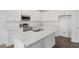 Modern kitchen with sleek white cabinetry, stainless steel appliances, an island, and granite countertops at 3144 Suraj Cir, Tavares, FL 32778