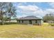Backyard features a well-maintained lawn with mature shade trees at 327 Larch Rd, Ocala, FL 34480