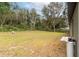 Large backyard featuring sprawling grass and trees, offering privacy and a peaceful setting at 327 Larch Rd, Ocala, FL 34480