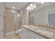Bathroom features a double sink vanity, granite countertops, and a tiled glass-enclosed shower at 327 Larch Rd, Ocala, FL 34480