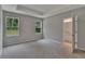 Carpeted bedroom with neutral colors, two windows, tray ceiling, and an ensuite bathroom at 327 Larch Rd, Ocala, FL 34480