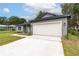 Home featuring an attached two-car garage and a long concrete driveway for easy parking at 327 Larch Rd, Ocala, FL 34480
