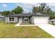 Charming single-story home featuring a well-maintained lawn, neutral paint, and an attached two-car garage at 327 Larch Rd, Ocala, FL 34480