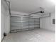 Spacious garage featuring a gray door and concrete flooring at 327 Larch Rd, Ocala, FL 34480