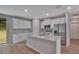 Modern kitchen featuring white cabinets, stainless steel appliances, and a granite island with sink at 327 Larch Rd, Ocala, FL 34480