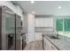 Bright kitchen featuring stainless steel appliances, granite counters and white cabinets at 327 Larch Rd, Ocala, FL 34480