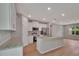 Bright, open kitchen features stainless appliances, granite countertops, white cabinets, and a large island at 327 Larch Rd, Ocala, FL 34480