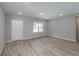 Spacious living area with wood-look flooring, a large window, and fresh neutral paint at 327 Larch Rd, Ocala, FL 34480