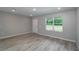 Bright living room featuring wood-look flooring, a large window, and neutral paint at 327 Larch Rd, Ocala, FL 34480