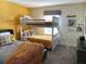 Cozy bedroom with a bunk bed, a full-size bed, and colorful bedding, perfect for or guests at 456 Ocean Course Ave, Davenport, FL 33896