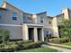 Modern two-story townhouse featuring a neutral color scheme, well-maintained landscaping, and a welcoming covered entrance at 456 Ocean Course Ave, Davenport, FL 33896