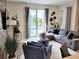 Well-decorated living room with modern decor, comfortable seating, and a sliding glass door view of the pool area at 456 Ocean Course Ave, Davenport, FL 33896