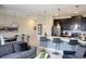 Open-concept living area featuring modern kitchen, dining area, and comfortable gray sofas, perfect for entertaining at 456 Ocean Course Ave, Davenport, FL 33896