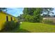 View of the backyard space, featuring a lush green lawn and trees at 4719 Miranda Cir, Orlando, FL 32818