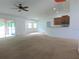 Bright living room with carpet, lots of light, ceiling fan, and view to a kitchen at 4852 Magnolia Preserve Dr, Winter Haven, FL 33880