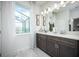 Bright bathroom featuring double vanity, elegant mirror, and modern fixtures with ample lighting and storage space at 5328 Teirgarten St, St Cloud, FL 34771