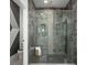 Modern bathroom with a glass-enclosed shower, dark tile, and sleek fixtures at 5328 Teirgarten St, St Cloud, FL 34771