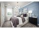 Serene bedroom features stylish blue accent wall and recessed lighting, creating a peaceful retreat at 5328 Teirgarten St, St Cloud, FL 34771