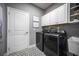 Functional laundry room featuring modern appliances, white cabinets, and stylish geometric flooring at 5328 Teirgarten St, St Cloud, FL 34771