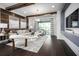 Elegant living room with hardwood floors, coffered ceilings, stylish decor, and access to a covered patio at 5328 Teirgarten St, St Cloud, FL 34771