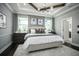 Inviting bedroom featuring a tray ceiling, neutral color palette, and large windows that provide ample natural light at 5328 Teirgarten St, St Cloud, FL 34771