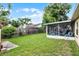 Backyard with a screened patio area and ample green space, perfect for outdoor activities and relaxation at 5815 England Ave, Orlando, FL 32808